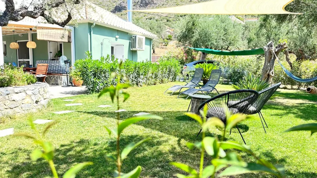 The house and garden at Villa Georgia, with sun loungers and a hammock under the olive trees